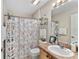 Cozy bathroom featuring a charming beach-themed shower curtain and ample shelving for storage at 17416 Se 71St Currituck Ter, The Villages, FL 32162