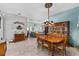Elegant dining room with wood table and chairs, decorative lighting, and open view to the living area at 17416 Se 71St Currituck Ter, The Villages, FL 32162