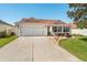 Charming single-story home with a two-car garage and a cozy outdoor seating area on the front yard at 17416 Se 71St Currituck Ter, The Villages, FL 32162