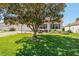 Charming house with a well-manicured lawn and a lovely seating area shaded by a large tree at 17416 Se 71St Currituck Ter, The Villages, FL 32162