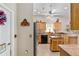 Well-equipped kitchen with wooden cabinets, modern appliances, and adjacent door to laundry room at 17416 Se 71St Currituck Ter, The Villages, FL 32162