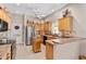 Spacious kitchen with wooden cabinets, stainless steel appliances, and adjacent laundry room at 17416 Se 71St Currituck Ter, The Villages, FL 32162