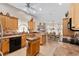 Bright kitchen with wooden cabinets, tiled backsplash, and view to dining area at 17416 Se 71St Currituck Ter, The Villages, FL 32162
