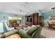 Spacious living room with comfortable seating, entertainment center, and view to the dining room at 17416 Se 71St Currituck Ter, The Villages, FL 32162