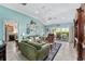 Bright living room with comfortable seating, sliding glass doors, and access to the kitchen at 17416 Se 71St Currituck Ter, The Villages, FL 32162