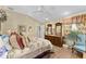 Well-lit main bedroom with floral bedding, and a dark wood dresser at 17416 Se 71St Currituck Ter, The Villages, FL 32162