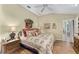 Bright main bedroom boasts wood floors, floral decor, and an ensuite bathroom at 17416 Se 71St Currituck Ter, The Villages, FL 32162
