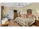 Spacious main bedroom with decorative bed, ensuite access and wood flooring at 17416 Se 71St Currituck Ter, The Villages, FL 32162