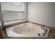 Corner bathtub with tile surround and a window at 17421 Woodfair Dr, Clermont, FL 34711