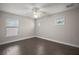 Bedroom featuring wood flooring, ceiling fan, neutral paint, and multiple windows at 17421 Woodfair Dr, Clermont, FL 34711