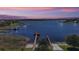 Breathtaking lake view featuring a community dock with boat ramp during sunset at 17421 Woodfair Dr, Clermont, FL 34711