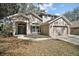Two-story home featuring a well-manicured lawn, mature landscaping, and a two-car garage at 17421 Woodfair Dr, Clermont, FL 34711