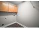 Neat laundry room with wooden cabinets above the hookups and clean wood-look floors at 17421 Woodfair Dr, Clermont, FL 34711