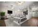 Open-concept living room showcasing a flat-screen TV, modern furniture, and hardwood floors at 17421 Woodfair Dr, Clermont, FL 34711