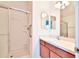 Bathroom features a vanity with a single sink, shower stall and decorative mirrors at 1805 Endsley Ct, The Villages, FL 32162