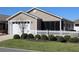 Attractive home showcasing the manicured lawn, white picket fence, and screened-in porch at 1805 Endsley Ct, The Villages, FL 32162
