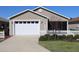 Charming home with a well-manicured front yard, white picket fence, and attached two-car garage at 1805 Endsley Ct, The Villages, FL 32162