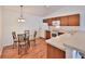 Eat-in kitchen features wood cabinets, white appliances, and a modern lighting fixture at 1805 Endsley Ct, The Villages, FL 32162