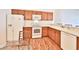 Well-lit kitchen boasts wood cabinets, a white refrigerator, range, and dishwasher at 1805 Endsley Ct, The Villages, FL 32162