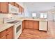 Open kitchen with wood cabinets, laminate counters, and a view to the living area at 1805 Endsley Ct, The Villages, FL 32162