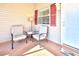 Relaxing outdoor seating area with red shutters and a welcome mat, perfect for enjoying the outdoors at 1805 Endsley Ct, The Villages, FL 32162