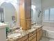 Bright bathroom featuring a double sink vanity, granite countertops, tub and window with shutters at 1970 Farmington Ct, Clermont, FL 34711