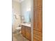 Well-lit bathroom featuring a vanity with a granite countertop and a storage cabinet at 1970 Farmington Ct, Clermont, FL 34711