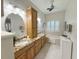 Bright bathroom featuring a double sink vanity, granite countertops, and tub and window with shutters at 1970 Farmington Ct, Clermont, FL 34711
