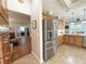 Well-lit kitchen featuring stainless steel refrigerator and view to the office through a dining room area at 1970 Farmington Ct, Clermont, FL 34711