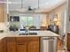 Kitchen island with stainless steel dishwasher, double basin sink, and view to the dining room at 1970 Farmington Ct, Clermont, FL 34711