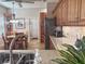 Kitchen island with double basin sink, stone countertops, and wooden pantry and refrigerator in background at 1970 Farmington Ct, Clermont, FL 34711