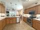 Bright kitchen with stainless steel appliances, wooden cabinets, and view to the dining room area at 1970 Farmington Ct, Clermont, FL 34711