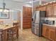 Kitchen with stainless steel refrigerator and wooden pantry next to a dining table and chairs at 1970 Farmington Ct, Clermont, FL 34711