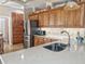 Kitchen with double basin sink, stone countertops, wooden cabinets and stainless steel refrigerator at 1970 Farmington Ct, Clermont, FL 34711