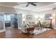 Spacious living room with wood floors, neutral furniture, and French doors leading to an office at 1970 Farmington Ct, Clermont, FL 34711