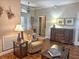 Cozy living room featuring warm hardwood floors, a comfortable armchair, and elegant decor at 1970 Farmington Ct, Clermont, FL 34711