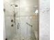 Shower featuring tile surround, glass door, bench, and grab bar; multiple shower heads at 1970 Farmington Ct, Clermont, FL 34711