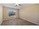 Bedroom with neutral color palette, plush carpet, and a window offering natural light at 20740 Queen Alexandra Dr, Leesburg, FL 34748