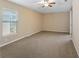 Large bedroom with plush carpeting, ceiling fan, and bright natural light at 20740 Queen Alexandra Dr, Leesburg, FL 34748