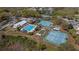Aerial view of the community amenities including a pool, tennis courts, clubhouse, and parking at 20740 Queen Alexandra Dr, Leesburg, FL 34748