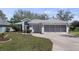 Charming single-story home featuring well-manicured lawn, two-car garage, and screened-in porch at 20740 Queen Alexandra Dr, Leesburg, FL 34748