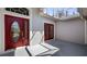 Inviting front entrance featuring a beautiful red door and glass sidelights at 20740 Queen Alexandra Dr, Leesburg, FL 34748