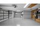 Spacious three car garage with epoxy flooring, updated lighting, and attached cabinets at 20740 Queen Alexandra Dr, Leesburg, FL 34748