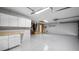 Spacious garage features epoxy floors, white cabinets and plenty of room for storage and work space at 20740 Queen Alexandra Dr, Leesburg, FL 34748