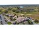Aerial view of a golf course with lush greens, surrounding homes, a clubhouse and a scenic pond at 20740 Queen Alexandra Dr, Leesburg, FL 34748