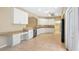 Bright kitchen with white cabinets, tiled floor, stainless steel dishwasher, and modern countertops at 20740 Queen Alexandra Dr, Leesburg, FL 34748