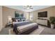 Main bedroom suite featuring a plush bed, TV, modern art, ceiling fan and ample natural light at 20740 Queen Alexandra Dr, Leesburg, FL 34748