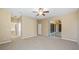 Spacious main bedroom with ceiling fan, neutral color palette, and large sliding glass doors to lanai at 20740 Queen Alexandra Dr, Leesburg, FL 34748