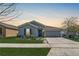 Charming single-story home with a well-manicured lawn, gray siding, and a two-car garage, perfect for a small Gathering at 212 Taft Dr, Davenport, FL 33837