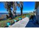 Lush backyard with picturesque lake views, vibrant potted plants, and charming blue patio furniture at 2225 Cypress Ct # 2C, Tavares, FL 32778